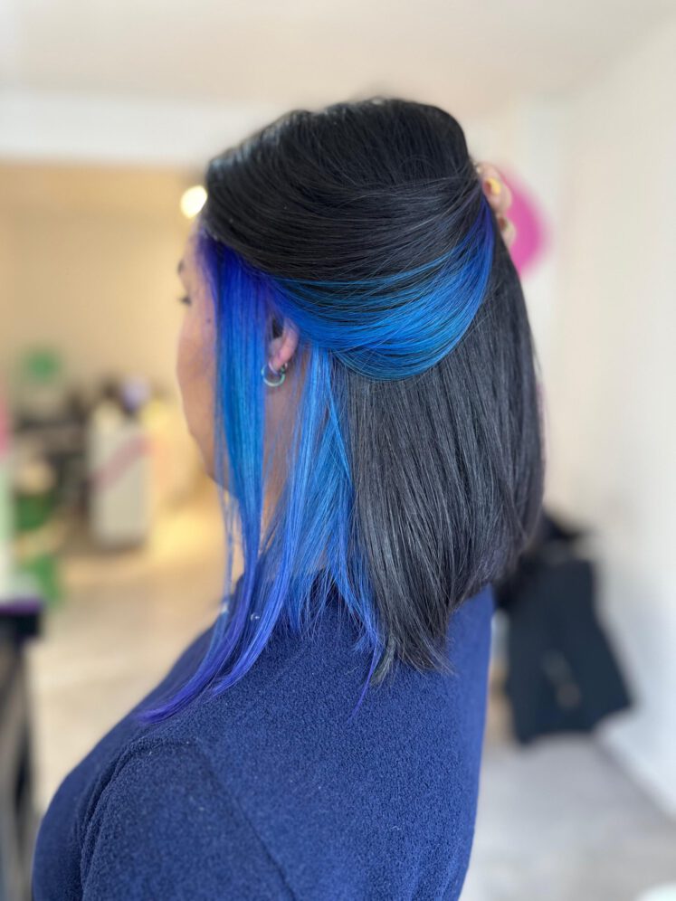 Mujer de perfil mostrando algunos mechones de cabello de color azul fantasía