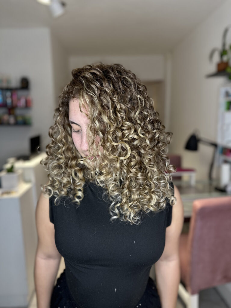 Mujer de frente mostrando iluminaciones platinadas en cabello castaño